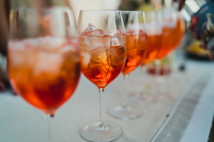 A row of wine glasses with aperol spritzes at a bar near Soltra Kierland apartments for rent in Scottsdale, AZ.