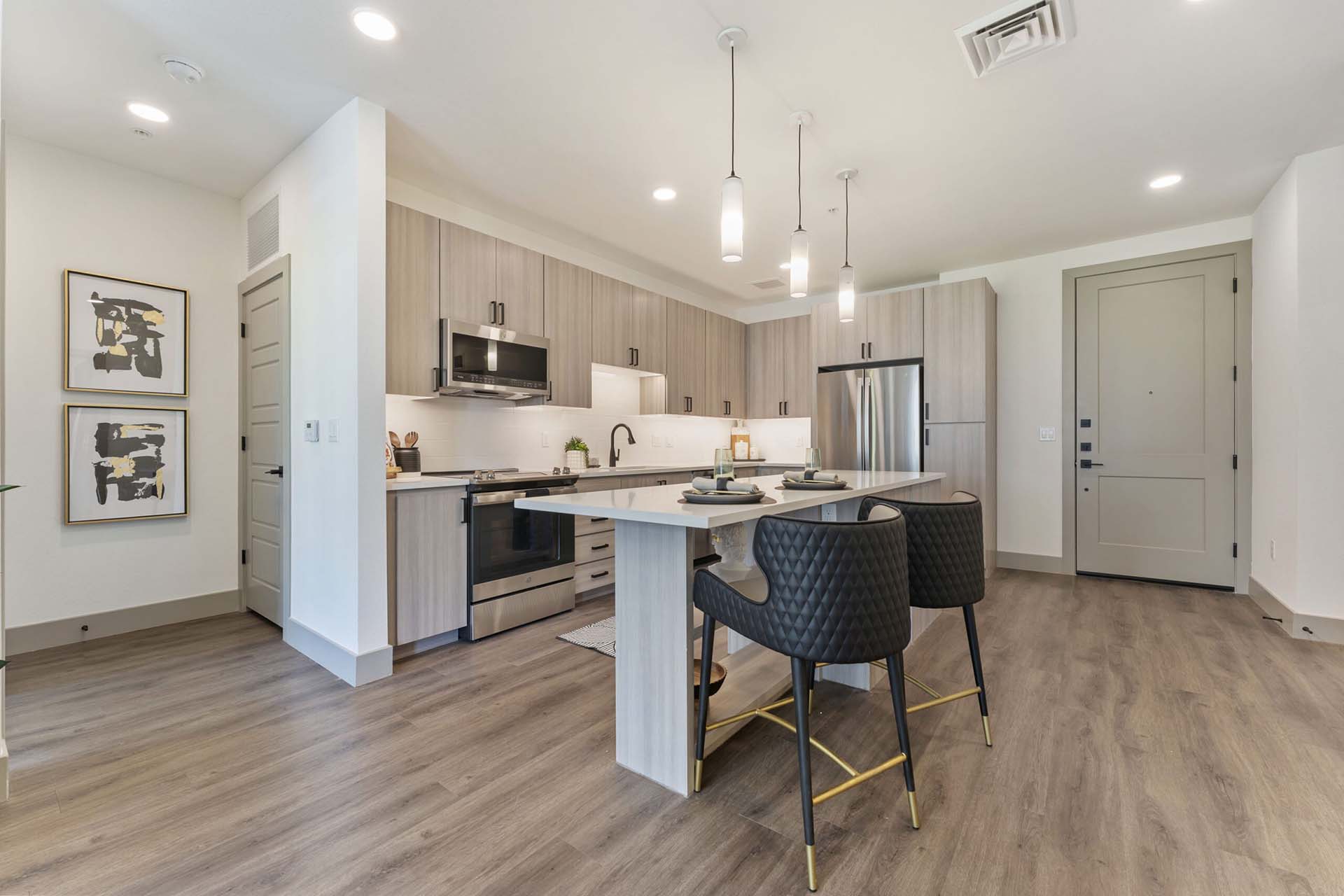 Model kitchen at Soltra Kierland apartments for rent in Scottsdale, AZ, featuring a kitchen island and wood grain flooring.
