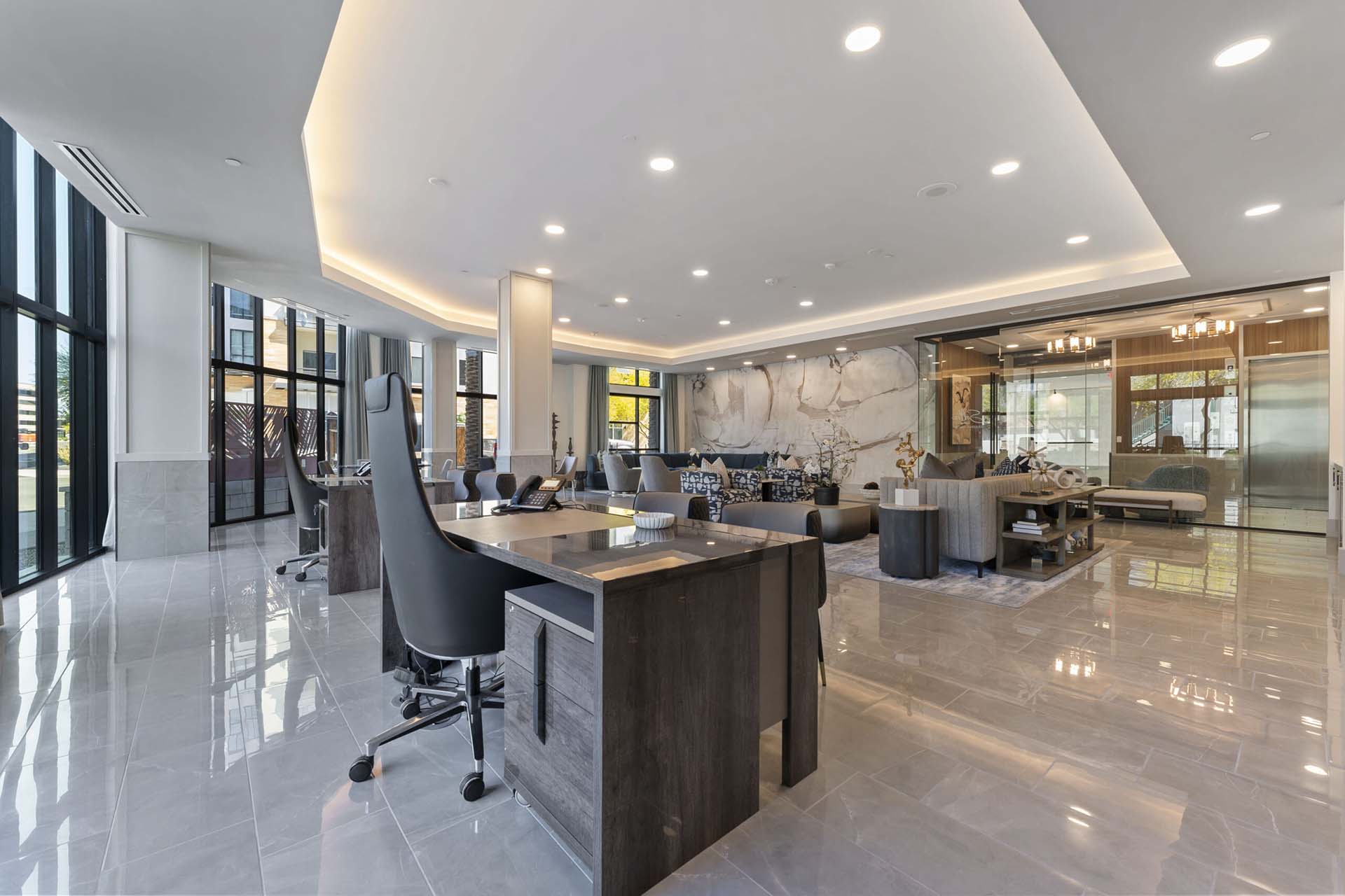 Leasing office lobby at Soltra Kierland with modern desks, executive chairs, tile flooring, and lounge seating area.