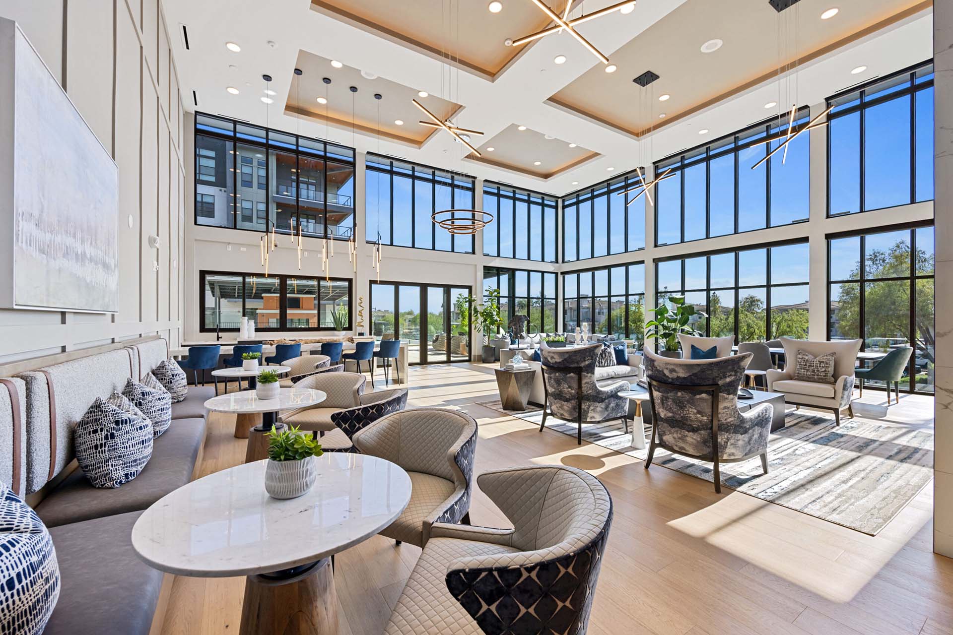 Spacious clubhouse lounge at Soltra Kierland with high ceilings, large windows, banquette seating, and modern armchairs.